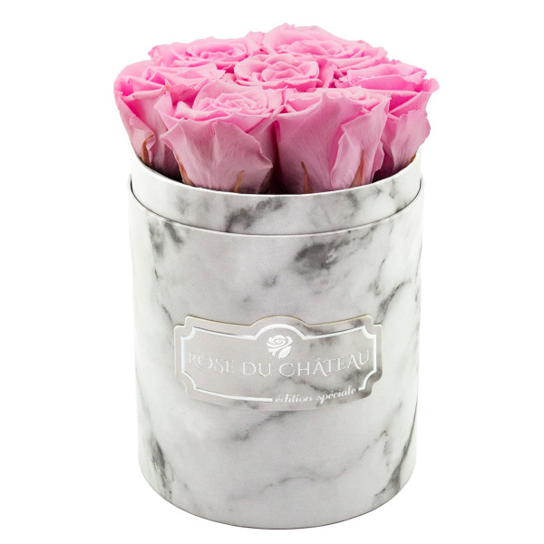 Světle růžové věčné růže v malém bílém mramorovém flowerboxu